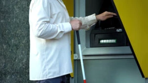 persoană oarbă la bancomat, card bancar tactil pentru persoane nevăzătoare