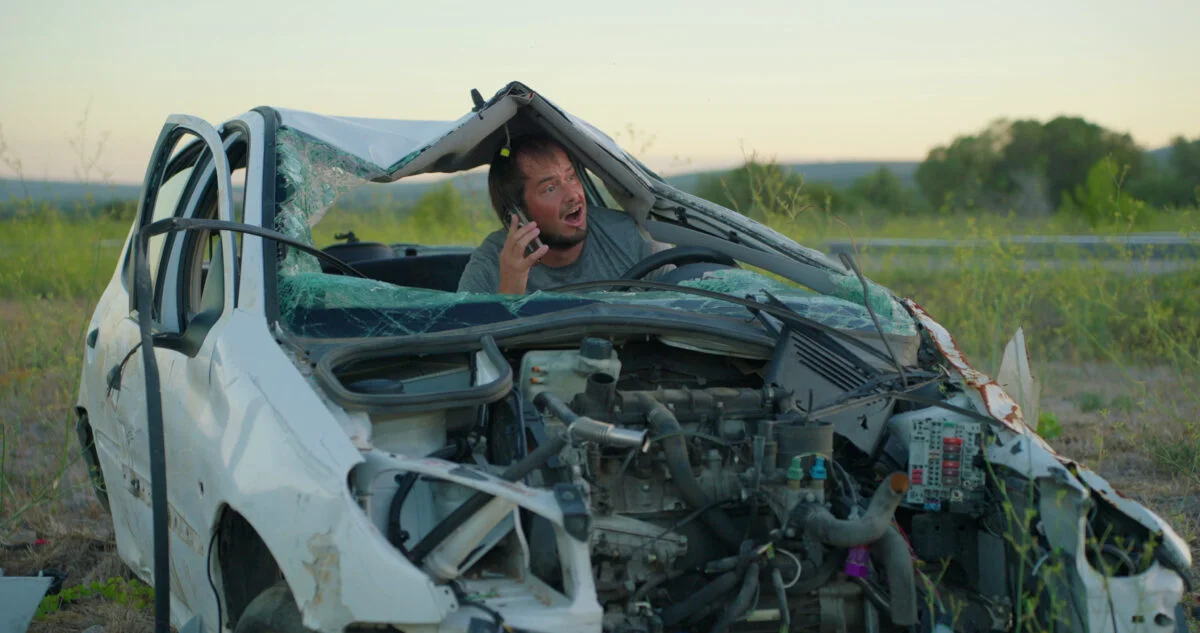 a-man-sits-in-his-car-destroyed-in-a-car-accident-and-tries-to-call-the-insurance-comp-SBI-349401177