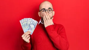 Un bărbat cu bancnote de 100 de lei