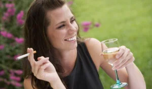 Femeie care fumează și bea vin