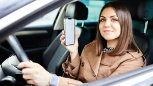 Femeie la volan, şofer cu telefonul mobil