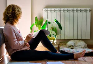 plafonare gaze, femeie langa un calorifer, incalzire, termoficare